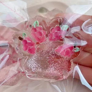 Close-up of strawberry themed cat paw squishy toy with pink glitter inside