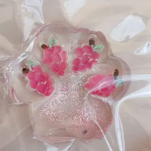 Macro detail of a transparent strawberry cat paw squishy toy with pink glitter inside