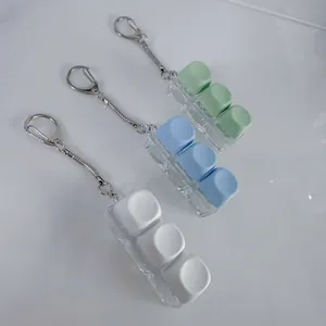 Detail of three mechanical keyboard switch keychain fidget toys in pastel colors