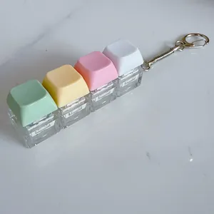 Close-up view of macaron colored mechanical keyboard keycap fidget toy keychain on white marble