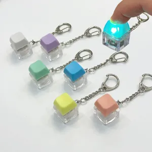 Close-up of a finger pressing a macaron color light-up keyboard switch fidget keychain