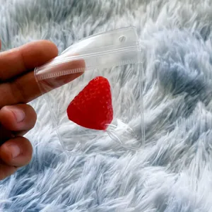 Detailed shot of a red strawberry squishy toy inside a clear plastic packaging bag