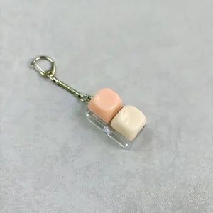 Detailweergave van macaron-snoepkleurige hars toetskap sleutelhanger met glans