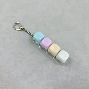 Detailweergave van de macaron pastel fidget knop sleutelhanger met 4 gekleurde toetsen