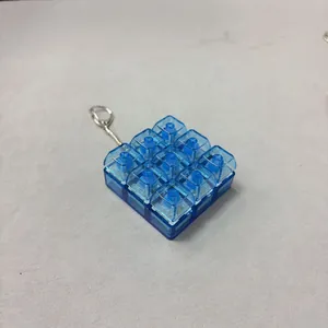 Detailed view showing the transparent blue 3x3 mechanical switch clicker keychain.