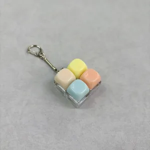 Close-up van de fidget keycap-sleutelhanger in macaronkleuren op grijs