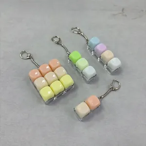 Detailweergave van verschillende configuraties van de macaronkleurige anti-stress sleutelhangers.