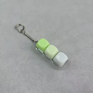 Detailed close-up of a mechanical switch fidget keychain with three gradient green keycaps