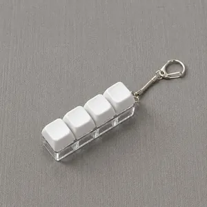 Close-up of a 4-key mechanical keyboard fidget toy keychain on grey background