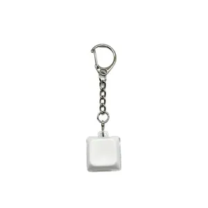 White mechanical keyboard keycap keychain for stress relief on a plain background
