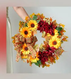 Detailed macro view of an autumn sunflower wreath featuring a plaid bow and fall foliage