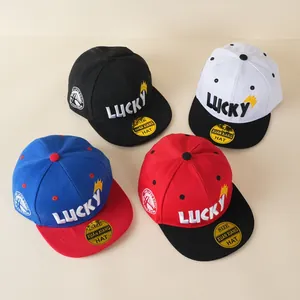 Hoge hoekweergave van vier verschillend gekleurde kinderhonkbalpetten met Lucky borduursel