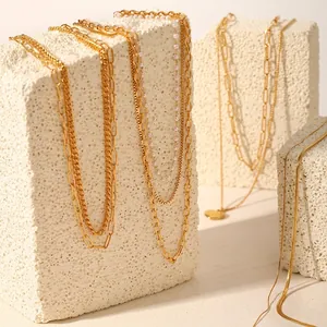 Close-up of 18k gold-plated layered stainless steel necklaces with pearls and heart pendant