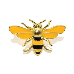 Close-up of a gold bumblebee napkin ring with yellow and black enamel detailing.