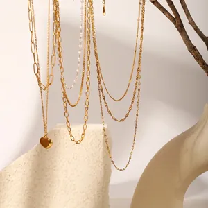 Detail of 18k gold plated stainless steel necklaces with heart pendant and paperclip chains.