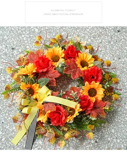 Close-up of autumn wreath with sunflowers, red roses, and striped bow detail.