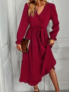 Elegant burgundy wrap dress featuring a tiered hem and a stylish tie-waist detail.