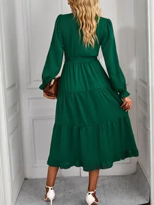 Back view of a long-sleeved dark green tiered maxi dress with ruffled hem and belt