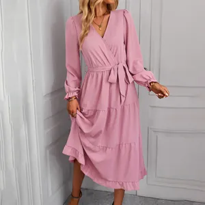 Detailed view of a pink V-neck long sleeve tiered midi dress with a waist tie.