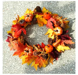 Detailed top view of an autumn harvest wreath featuring pumpkins, maple leaves and pinecones
