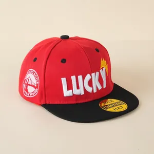 Detail van een rood-zwarte baseballpet met platte rand voor kinderen met Lucky-borduur.