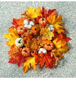 Close-up detail of autumn harvest wreath featuring maple leaves and mini pumpkins