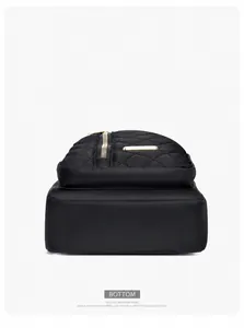 Detailed bottom view of a black quilted nylon chest bag featuring embroidery patterns