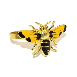 Close-up detail of a gold bee napkin ring with yellow and black enamel finish