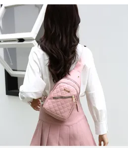 Close-up back view of a pink quilted sling bag worn by a model in a casual outdoor setting.