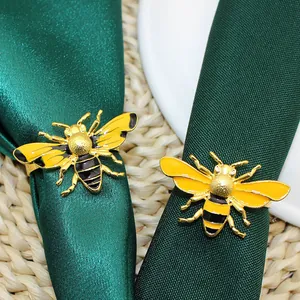 Enamel yellow honey bee napkin rings set of two on emerald green fabric for table decoration
