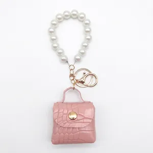 Llavero de mini bolso rosa en cuero PU con patrón de cocodrilo y correa de perlas
