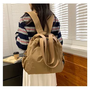Foto de estilo de vida de una elegante mochila caqui de gran capacidad usada por modelo