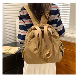 Vista detallada de una mochila marrón con cordón usada en un entorno de estilo minimalista