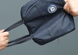Detailweergave van een duurzame blauwe Oxford lunchtas met een schattig beer-logo ontwerp