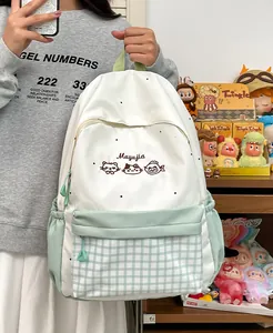 Detail view of cute cat embroidery and mint green plaid pocket on student backpack