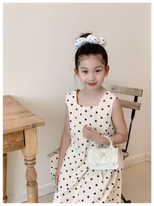 Young girl holding a sweet white princess handbag with elegant pearl handle detail.