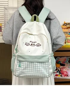 Back view of a cute white and mint green backpack with cat embroidery and checkered pocket.