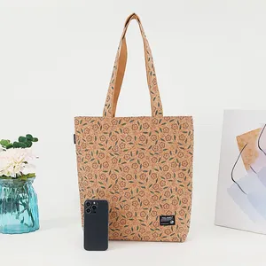 Detailed front view of eco-friendly cork floral tote bag next to phone for size