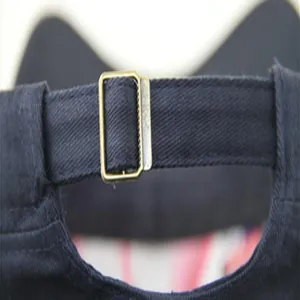 Detailed close-up showing the adjustable metal buckle strap on a navy blue cotton military cap