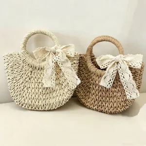 Paire de sacs à main en paille faits main avec nœuds en dentelle et anses rondes.