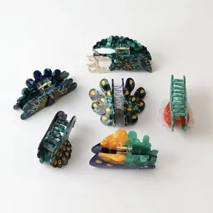 Detailed view of peacock-themed acetate hair claw clips in vibrant colors and patterns