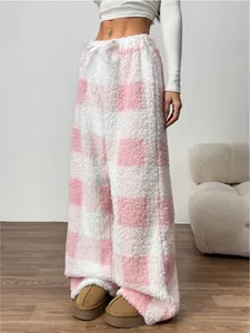 Close-up of soft pink and white checkered fleece pajama pants with loose fit for winter