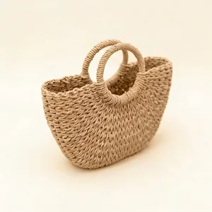 Vue détaillée d'un sac à main en paille beige tissé à la main avec des poignées rondes