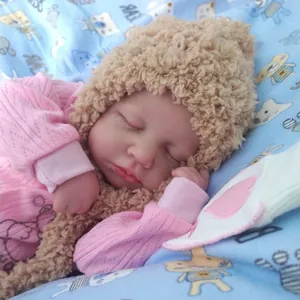 Detailed close-up of a 19-inch sleeping Loulou reborn baby doll in pink knitwear