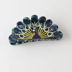 Detailed view of a decorative peacock-shaped hair claw clip made of colorful acetate