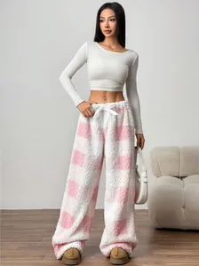 Full view of a model wearing pink and white checkered fuzzy plush lounge pants