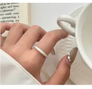 Nahaufnahme eines mattierten 925er Silberrings an einer Hand mit einer weißen Teetasse
