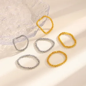 Eleganti anelli testurizzati in oro e argento su un piatto di vetro decorativo