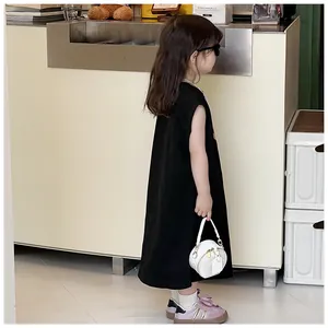 Detalle de una niña sosteniendo un mini bolso bandolera redondo blanco para niños