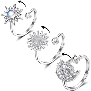 Macro detail of rotating anti-anxiety rings featuring sunflower and star moon designs